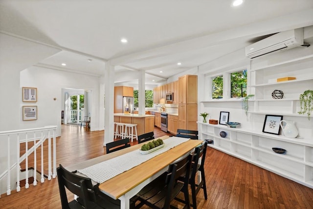 dining room with a wall unit AC, hardwood / wood-style floors, and a wealth of natural light