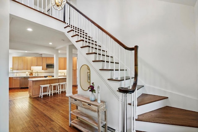 stairway with wood-type flooring and recessed lighting