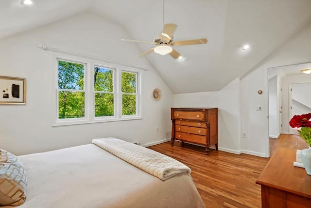 bedroom with baseboards, wood finished floors, and lofted ceiling
