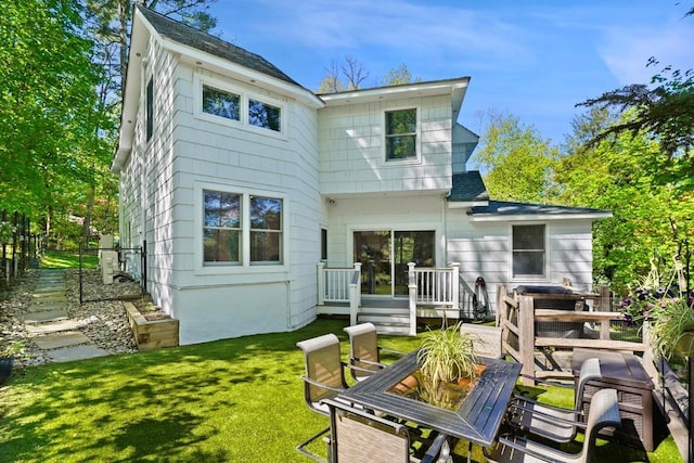 back of property with a lawn and a wooden deck