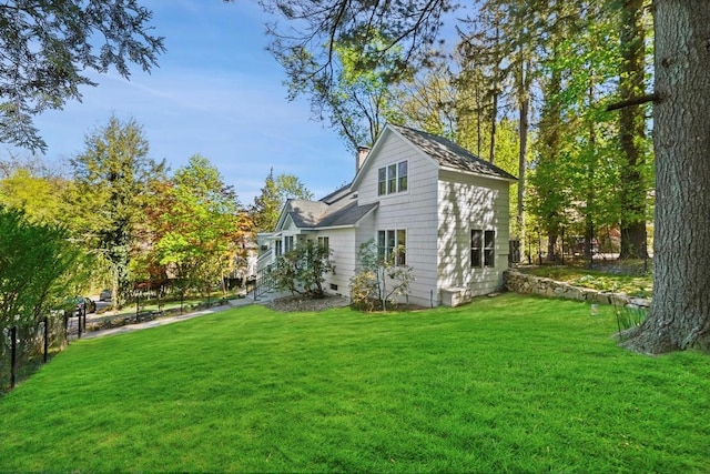 back of property featuring a lawn and a chimney