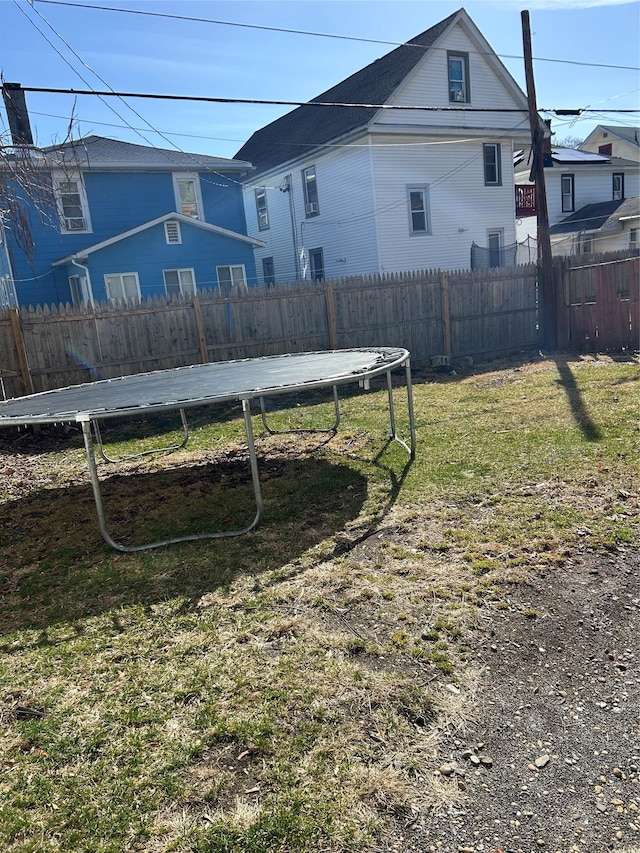 view of yard with fence and a trampoline