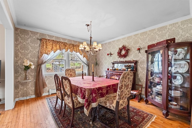 dining space with wallpapered walls, a baseboard heating unit, a notable chandelier, and hardwood / wood-style flooring
