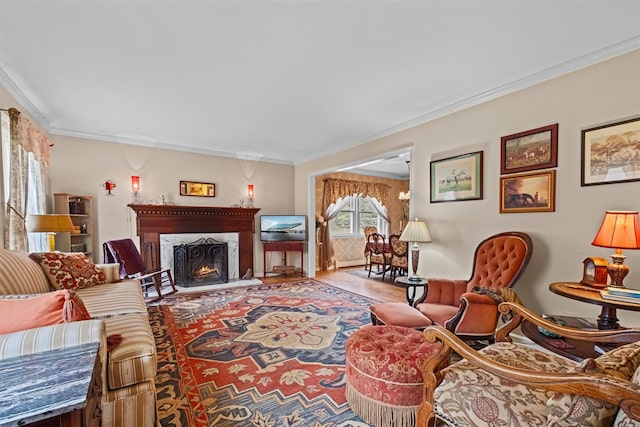 living area with ornamental molding, wood finished floors, and a lit fireplace