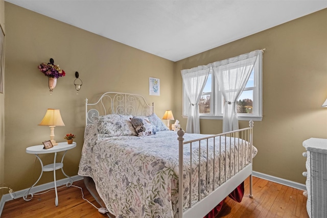 bedroom featuring wood-type flooring and baseboards
