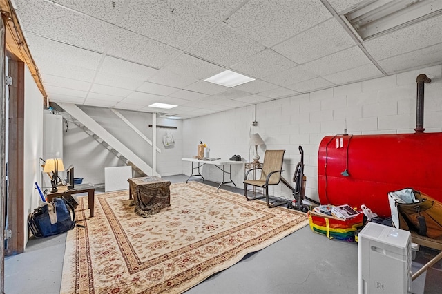 finished basement with a drop ceiling and concrete block wall