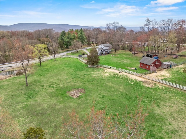 exterior space with a rural view, fence, an outbuilding, and a lawn
