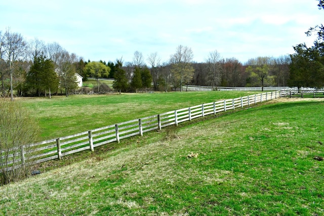 view of yard with a rural view and fence