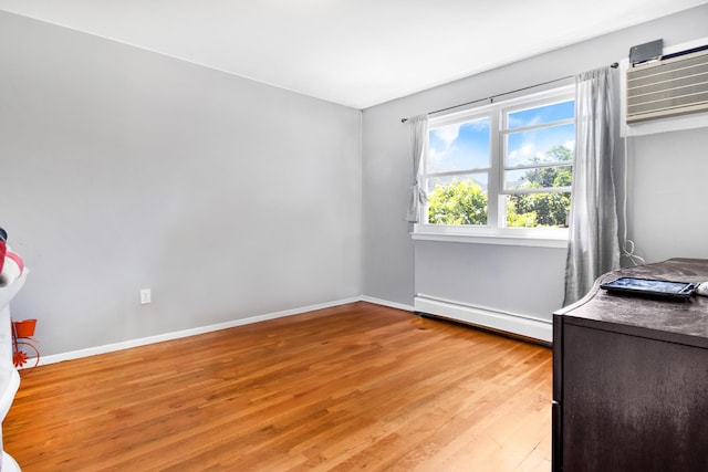 13506 62nd Rd, Flushing, NY 11367 - unfurnished bedroom featuring baseboard heating, light wood-style flooring, baseboards, and a wall mounted AC