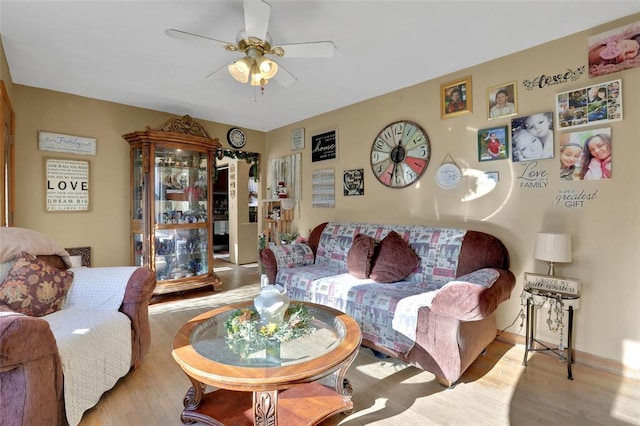 living area with wood finished floors, baseboards, and a ceiling fan