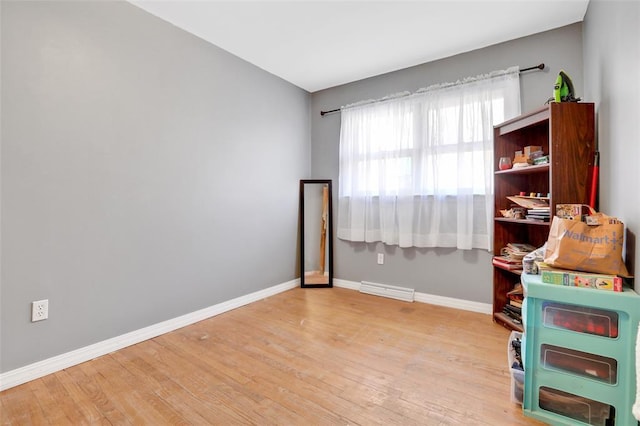 spare room with baseboards and wood finished floors