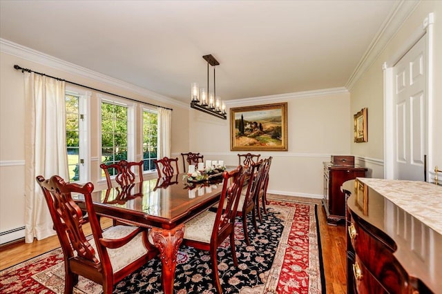 dining space with baseboards, ornamental molding, and wood finished floors