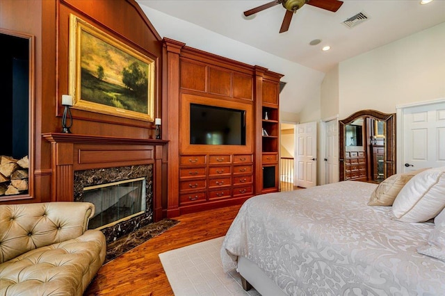 bedroom with dark wood-type flooring, visible vents, recessed lighting, and a premium fireplace