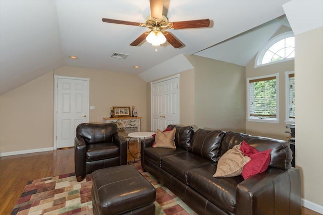 living room featuring visible vents, baseboards, vaulted ceiling, and wood finished floors