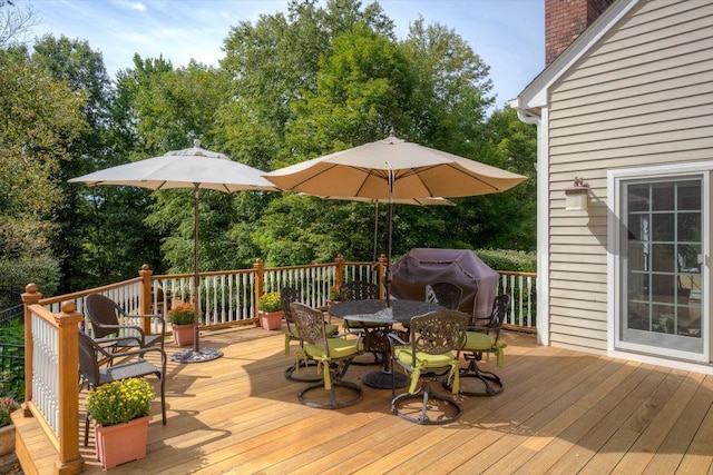 wooden deck with grilling area and outdoor dining space