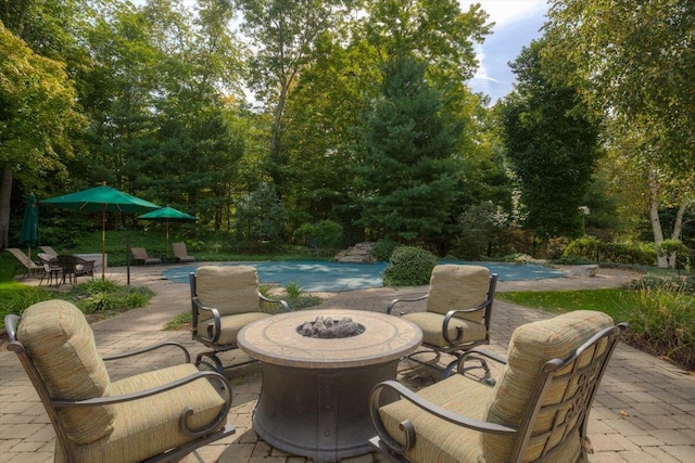 view of patio / terrace with a fire pit and an outdoor pool