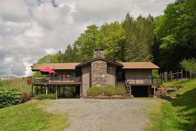 65 Deuner Hill Rd, Callicoon Center, NY 12723 - view of front of house featuring driveway, stone siding, a wooden deck, stairway, and a carport