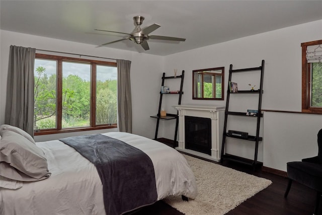 65 Deuner Hill Rd, Callicoon Center, NY 12723 - bedroom with wood finished floors, a glass covered fireplace, baseboards, and a ceiling fan
