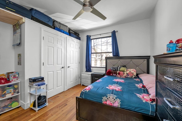 bedroom with a closet, light wood-style flooring, and a ceiling fan