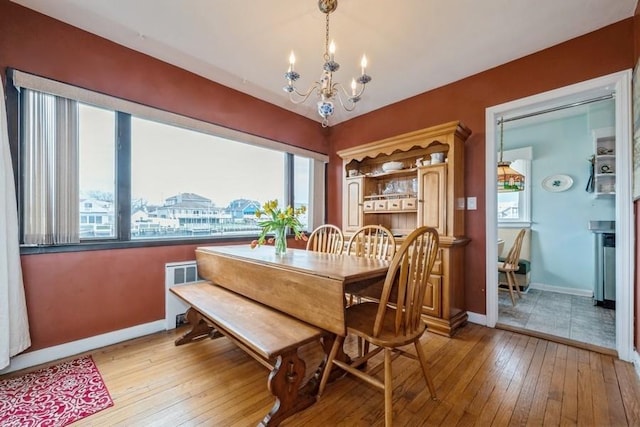 260 Washington Ave, Harbor Isle, NY 11558 - dining space featuring light wood finished floors, a wealth of natural light, a chandelier, and baseboards