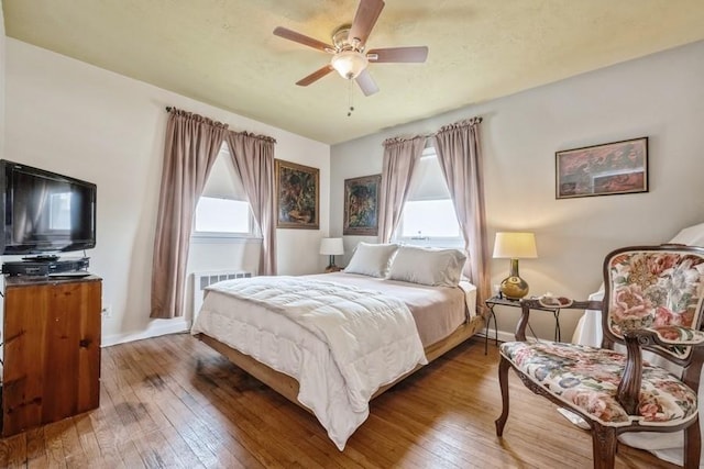 260 Washington Ave, Harbor Isle, NY 11558 - bedroom featuring radiator, a ceiling fan, multiple windows, and hardwood / wood-style floors