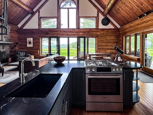 649 County Road 95, North Branch, NY 12766 - kitchen with stainless steel gas range, log walls, high vaulted ceiling, a wood ceiling with exposed beams, and dark wood-style floors