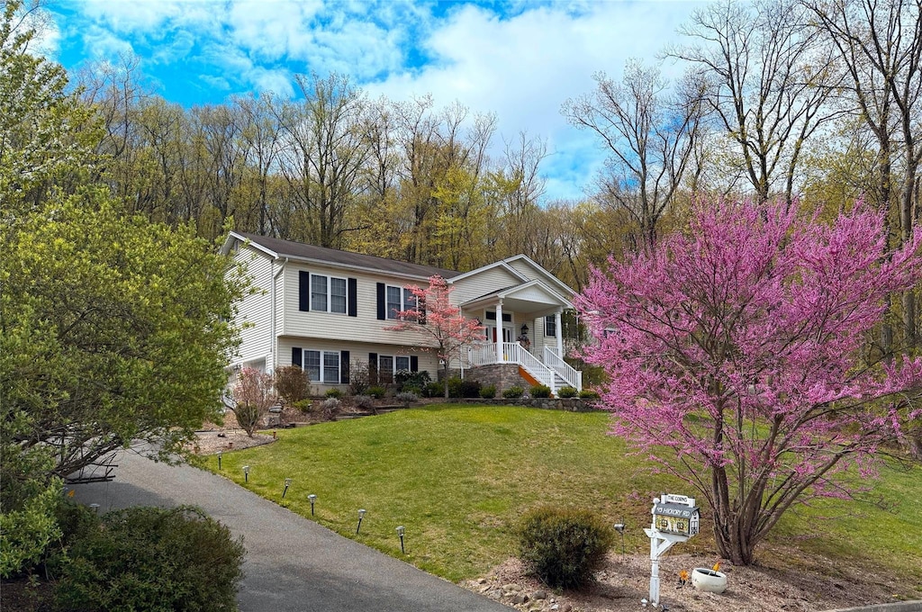 view of front of home featuring stairway, a porch, and a front yard