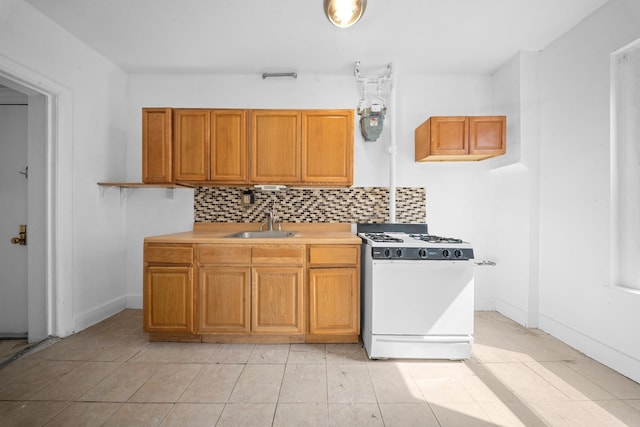 1001 Anderson Ave Unit 22, Bronx, NY 10452 - kitchen featuring white range with gas stovetop, decorative backsplash, light countertops, brown cabinets, and light tile patterned floors