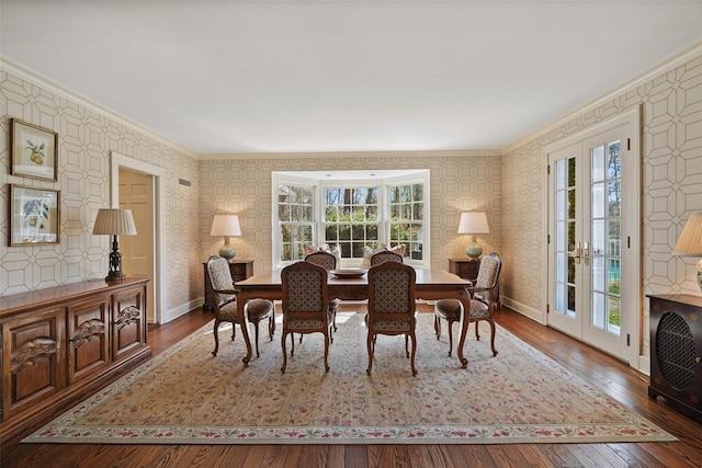 dining room with hardwood / wood-style flooring, baseboards, ornamental molding, and wallpapered walls