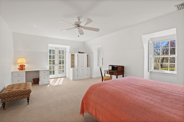bedroom featuring a ceiling fan, visible vents, light colored carpet, and multiple windows