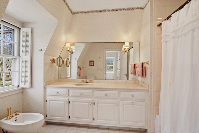 bathroom with a bidet, wallpapered walls, a healthy amount of sunlight, and vanity