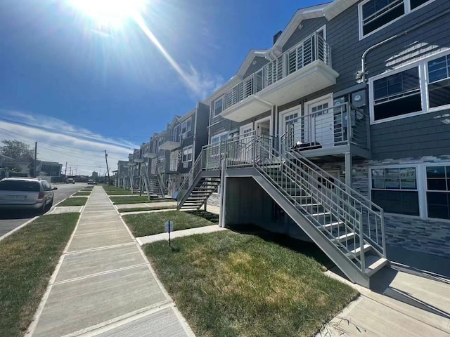 exterior space with stairs and a yard