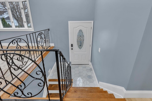 foyer with baseboards and stairway