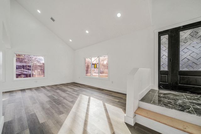 foyer with high vaulted ceiling and wood finished floors
