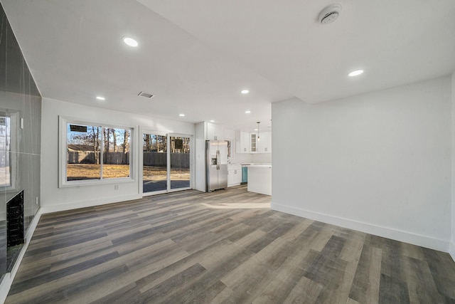 unfurnished living room featuring recessed lighting, baseboards, visible vents, and wood finished floors