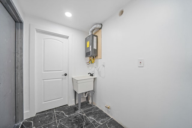 laundry room with baseboards, marble finish floor, laundry area, recessed lighting, and water heater