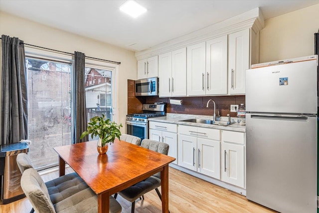 61-27 160th St, Fresh Meadows, NY 11365 - kitchen featuring light wood-type flooring, white cabinets, appliances with stainless steel finishes, light countertops, and a sink