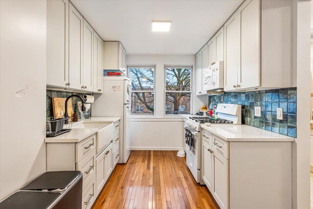 61-27 160th St, Fresh Meadows, NY 11365 - kitchen with light countertops, decorative backsplash, light wood-type flooring, and white appliances