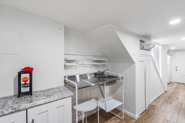 61-27 160th St, Fresh Meadows, NY 11365 - kitchen with white cabinetry, light wood finished floors, light stone counters, and a sink