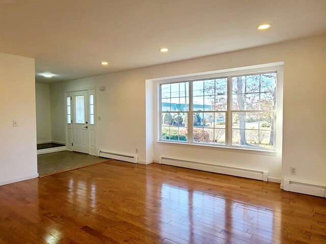 89 Railroad Ave, Center Moriches, NY 11934 - unfurnished living room featuring a baseboard radiator, hardwood / wood-style flooring, and recessed lighting