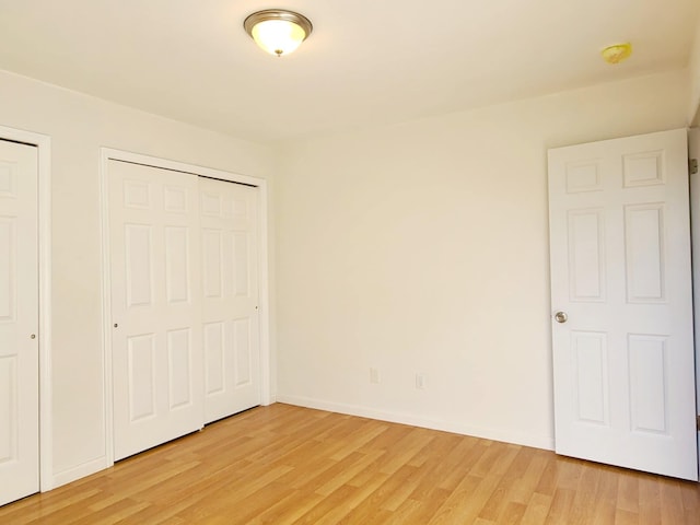 89 Railroad Ave, Center Moriches, NY 11934 - unfurnished bedroom featuring two closets, light wood-style flooring, and baseboards