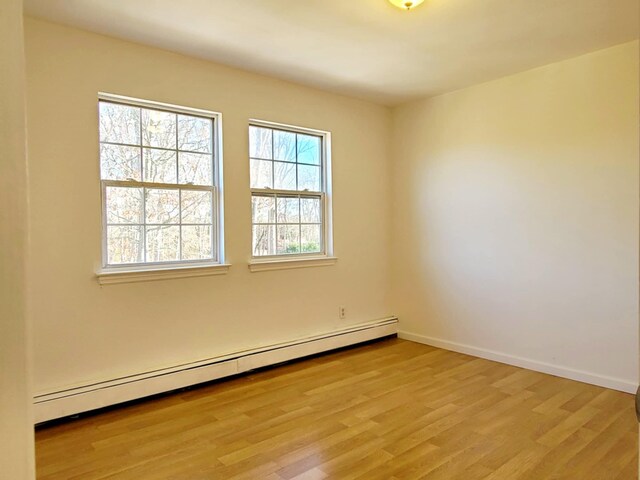 89 Railroad Ave, Center Moriches, NY 11934 - empty room with light wood finished floors, a baseboard radiator, and baseboards