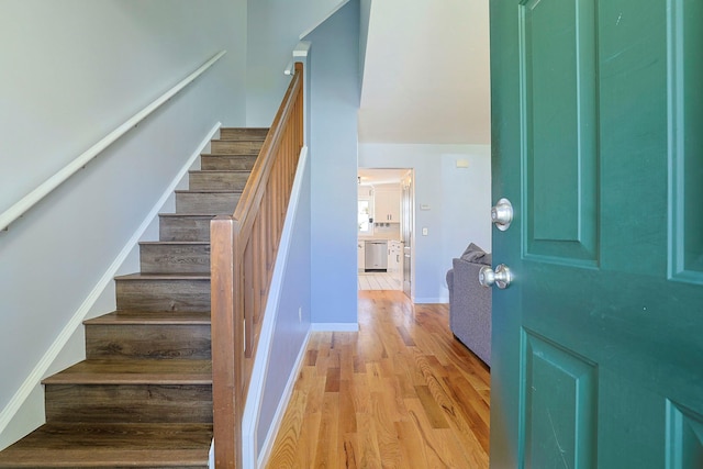 entrance foyer with stairs, baseboards, and light wood-type flooring