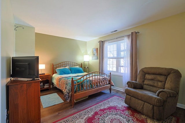 bedroom featuring baseboards, visible vents, and wood finished floors
