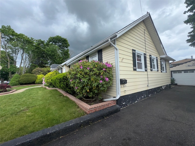 524 Polaris St, North Babylon, NY 11703 - view of side of home with a lawn, an outbuilding, and a detached garage