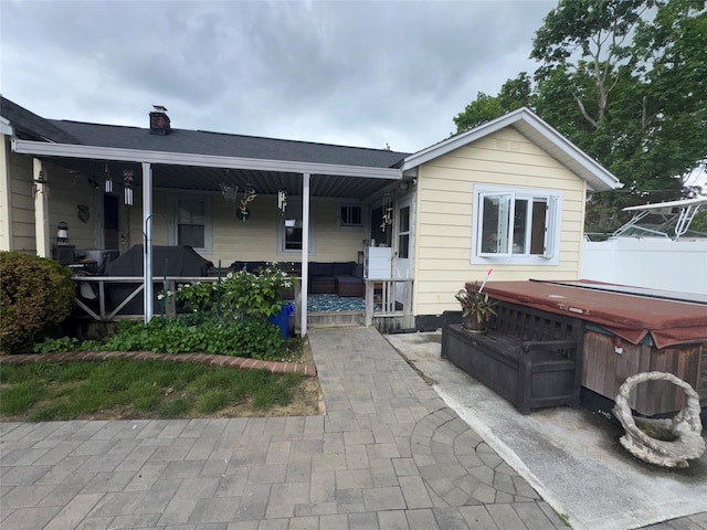 524 Polaris St, North Babylon, NY 11703 - view of front facade featuring a hot tub, a porch, and a chimney