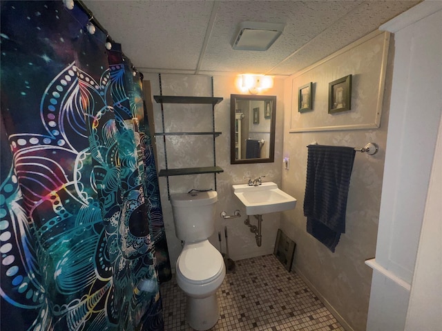 524 Polaris St, North Babylon, NY 11703 - bathroom featuring toilet, a paneled ceiling, tile patterned flooring, and a sink