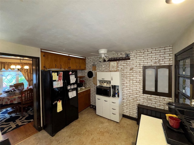 524 Polaris St, North Babylon, NY 11703 - kitchen featuring black appliances, ceiling fan, a chandelier, brick wall, and white cabinets