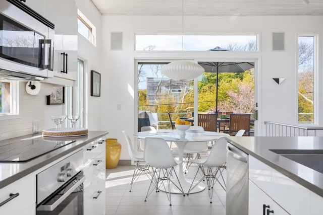 267 Floral Walk, Fire Island Pines, NY 11782 - kitchen with black electric cooktop, tasteful backsplash, dishwasher, white cabinets, and wall oven