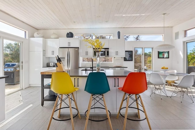 267 Floral Walk, Fire Island Pines, NY 11782 - kitchen featuring a kitchen bar, wooden ceiling, appliances with stainless steel finishes, and an island with sink